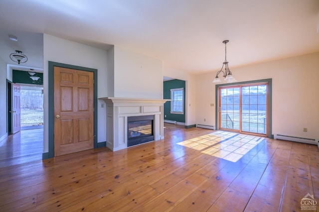 unfurnished living room featuring a baseboard radiator and light hardwood / wood-style floors