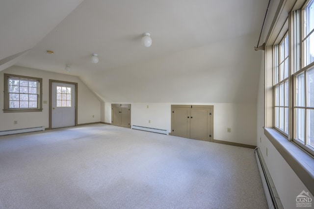 bonus room with lofted ceiling, a baseboard heating unit, and light carpet