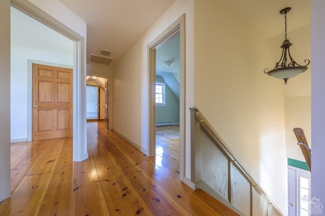 corridor with light hardwood / wood-style flooring and baseboard heating