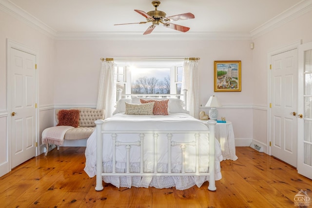 bedroom featuring light hardwood / wood-style floors, ceiling fan, and crown molding