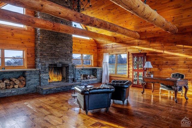 living room with hardwood / wood-style floors, beam ceiling, and a stone fireplace