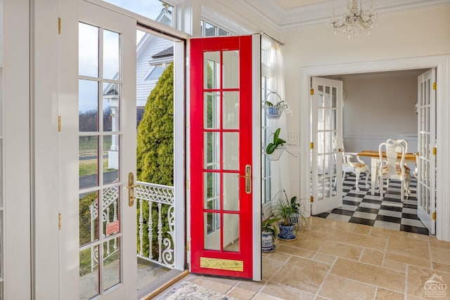 doorway to outside featuring french doors, crown molding, and an inviting chandelier