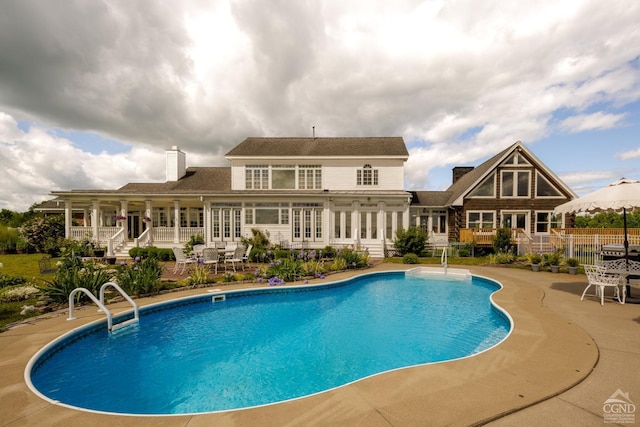 view of swimming pool with french doors and a patio area