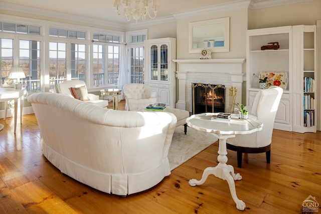 interior space featuring a chandelier, light hardwood / wood-style floors, a brick fireplace, and crown molding