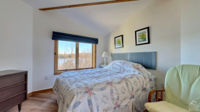 bedroom featuring vaulted ceiling with beams and light wood-type flooring