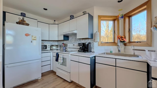 kitchen with white appliances, sink, light hardwood / wood-style flooring, tasteful backsplash, and white cabinetry