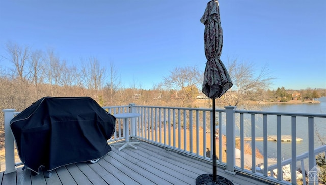 wooden terrace with a grill and a water view