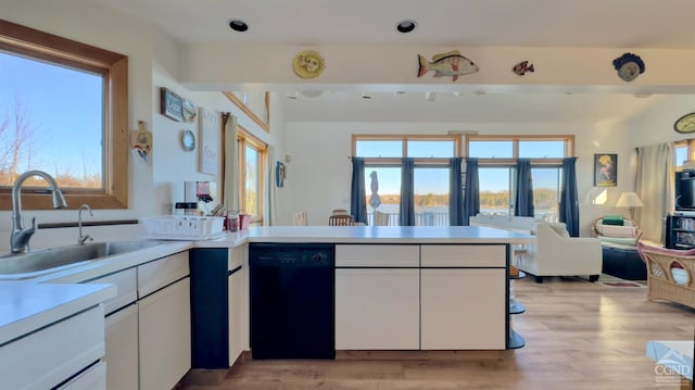 kitchen with dishwasher, white cabinets, sink, light hardwood / wood-style floors, and kitchen peninsula