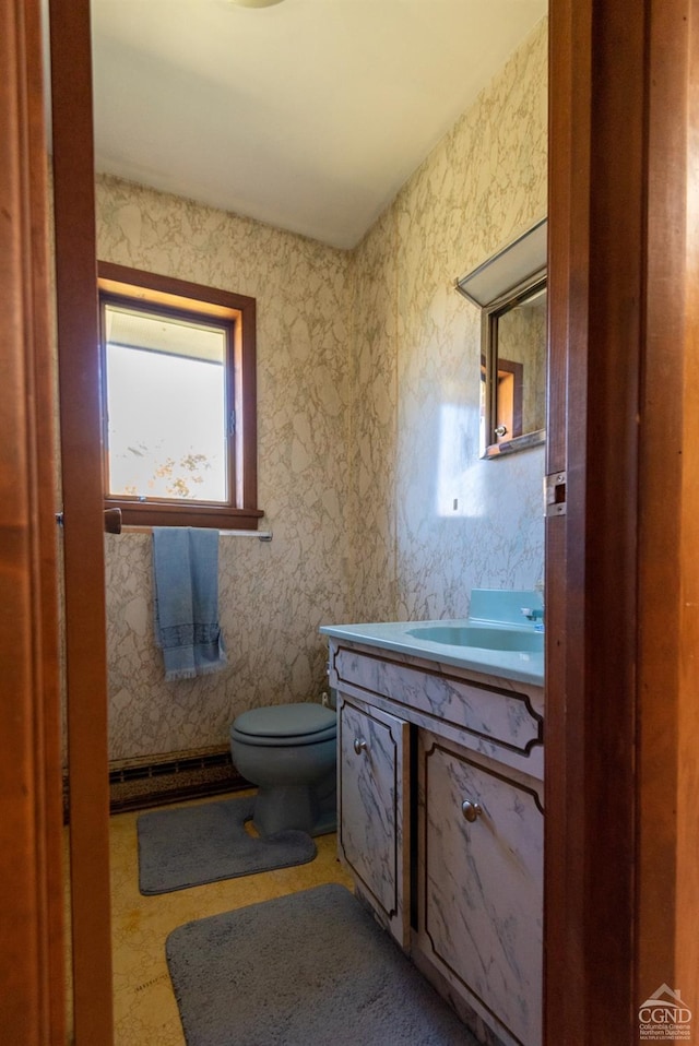 bathroom with vanity, toilet, and a baseboard heating unit