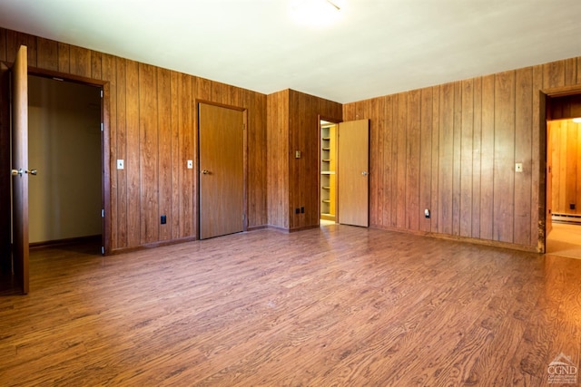 unfurnished bedroom featuring hardwood / wood-style floors and wooden walls