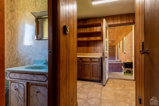 bathroom featuring wooden walls and vanity