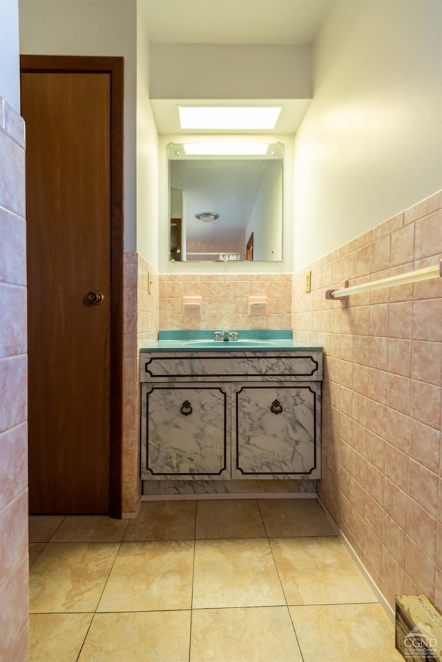 bathroom featuring tile patterned flooring, vanity, and tile walls