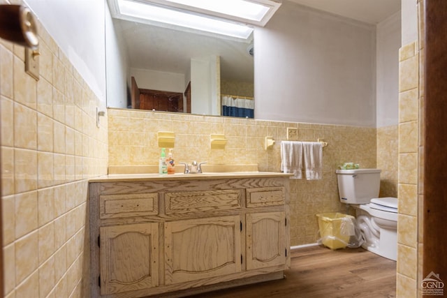 bathroom with hardwood / wood-style floors, vanity, tile walls, and toilet