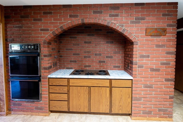 kitchen with white electric cooktop, light stone counters, and double oven