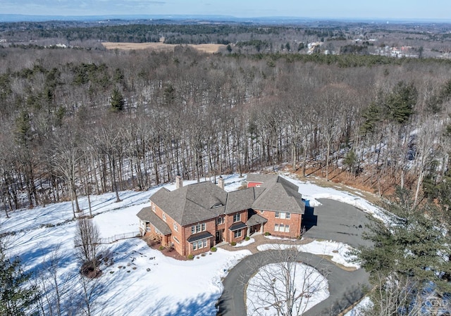 snowy aerial view featuring a forest view