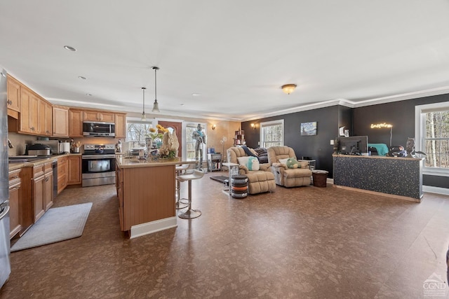 kitchen featuring dark floors, a center island, pendant lighting, appliances with stainless steel finishes, and a kitchen breakfast bar