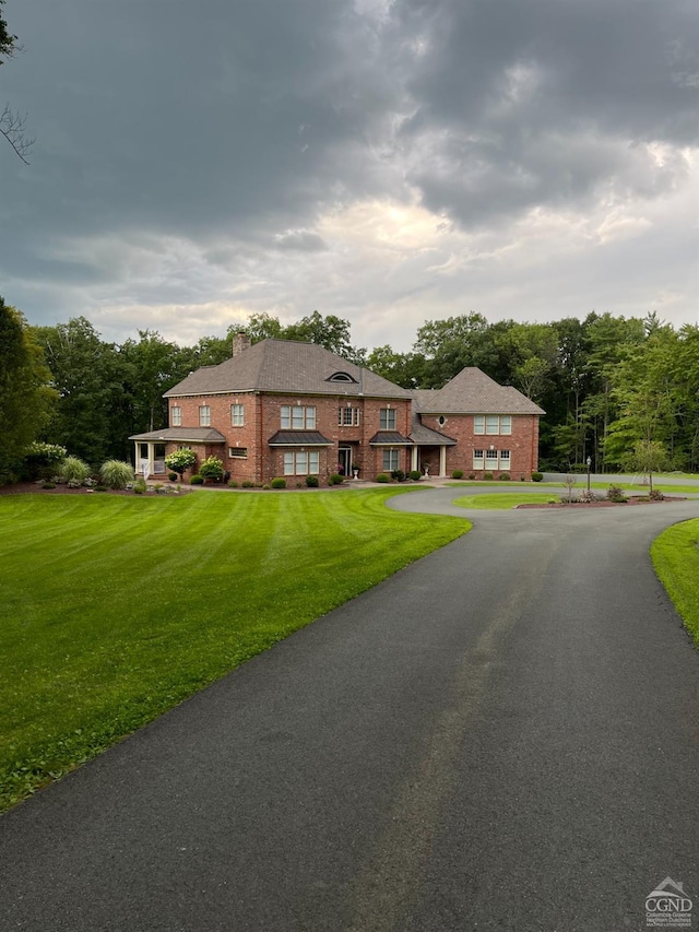 view of front of home featuring brick siding and a front lawn