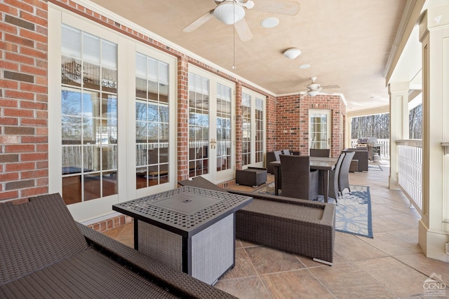 sunroom featuring ceiling fan and ornate columns