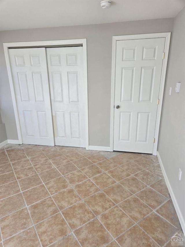 unfurnished bedroom featuring tile patterned flooring and a closet