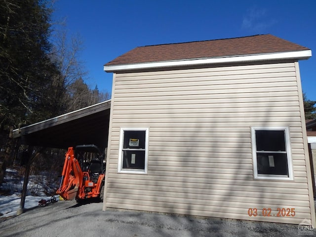 view of home's exterior featuring a carport and a shingled roof