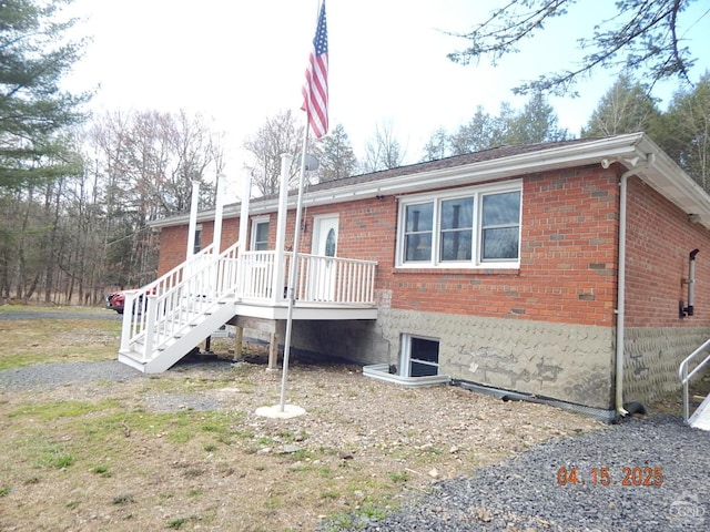 back of property featuring brick siding and stairs