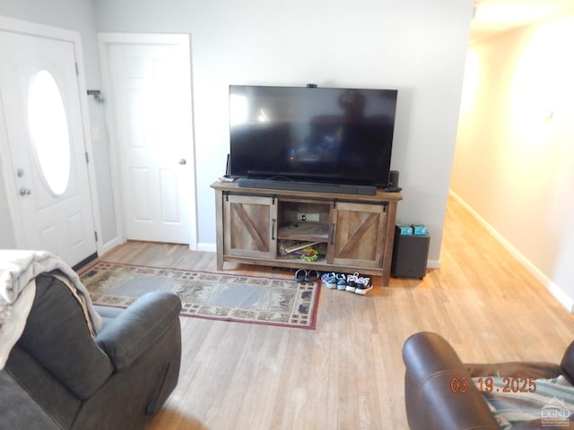 living area with baseboards and wood finished floors