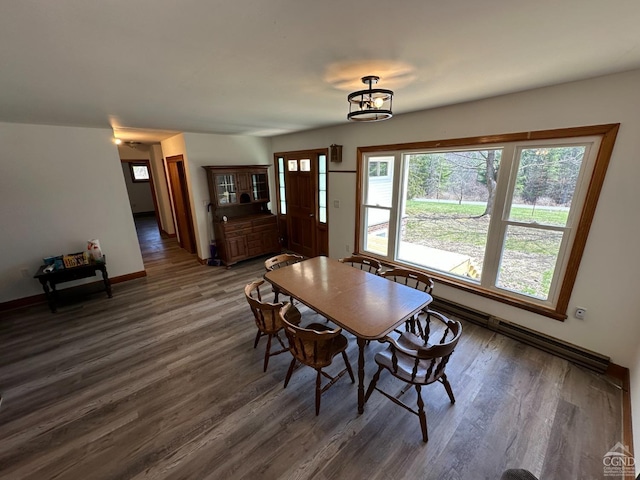 dining space with baseboards, a wealth of natural light, and wood finished floors
