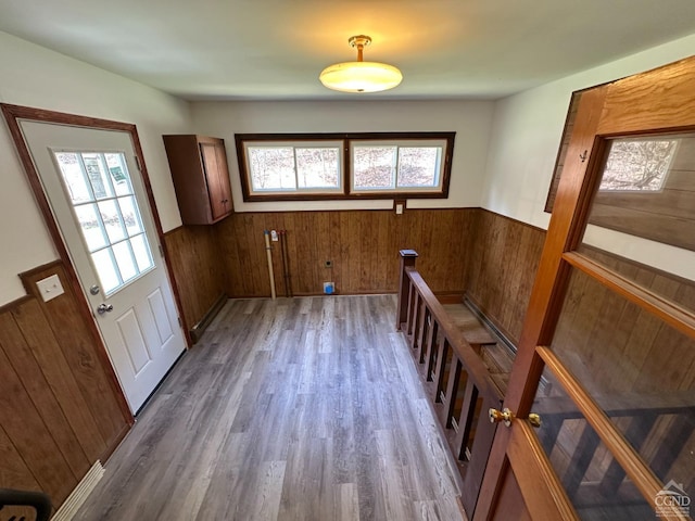 entryway featuring wood walls, wainscoting, and a wealth of natural light