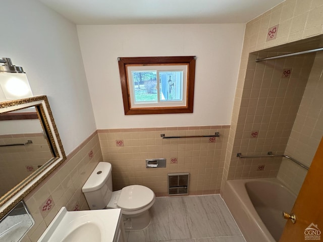 bathroom featuring wainscoting, tile walls, vanity, and toilet