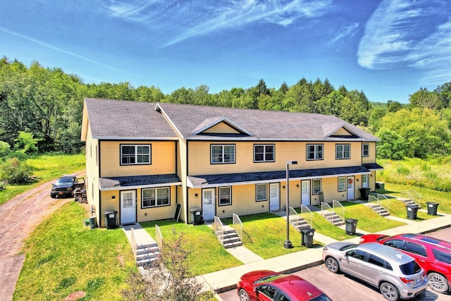 view of property featuring central AC and a front yard