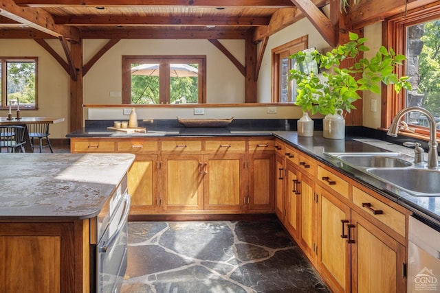 kitchen featuring beam ceiling, a wealth of natural light, and sink