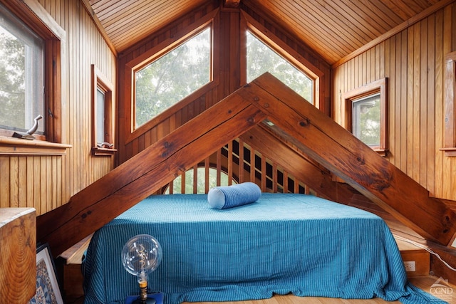 bedroom featuring lofted ceiling, wooden walls, and wooden ceiling