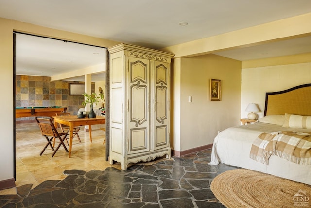 bedroom with tile walls and pool table