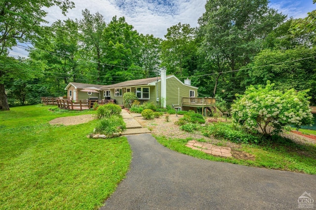 view of front facade with a deck and a front lawn