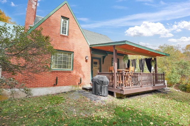 back of house featuring a lawn and a wooden deck