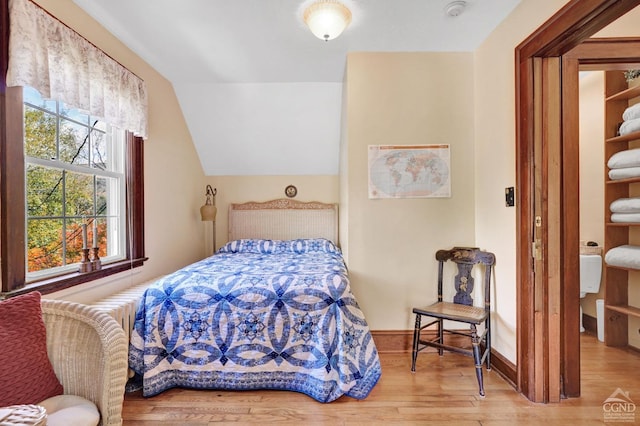 bedroom with light hardwood / wood-style floors and vaulted ceiling