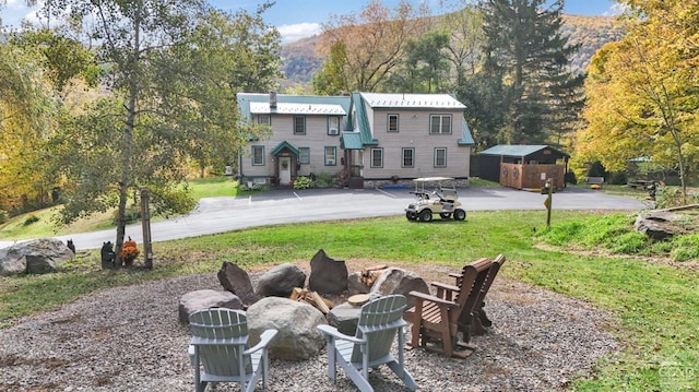 back of house with a mountain view and a yard