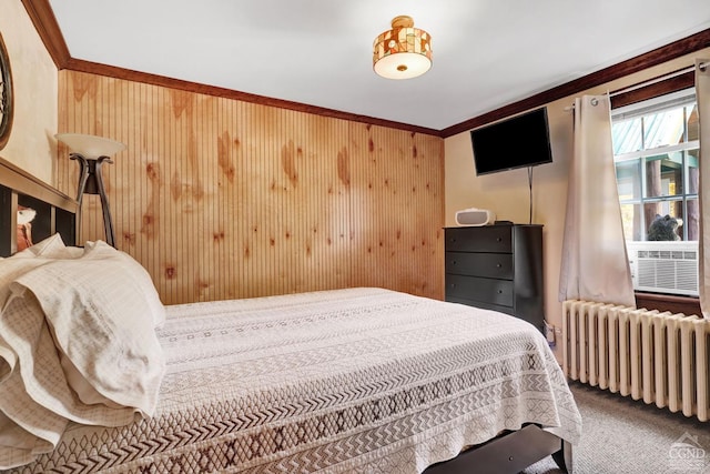 bedroom with crown molding, carpet floors, radiator, and wooden walls