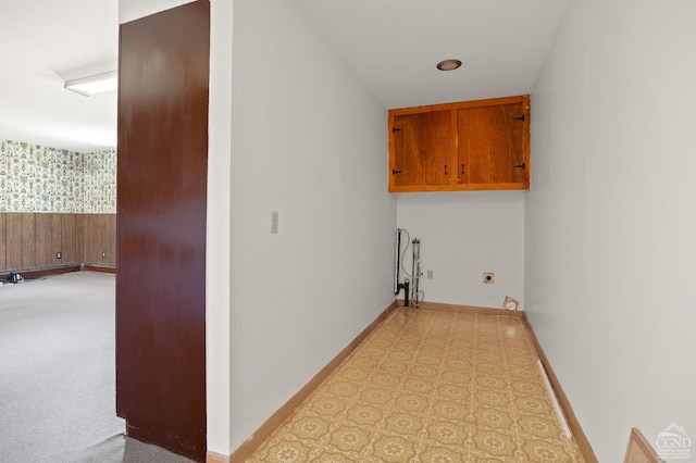 laundry area with electric dryer hookup and cabinets