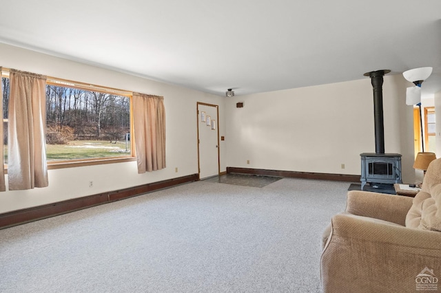 living room featuring carpet and a wood stove