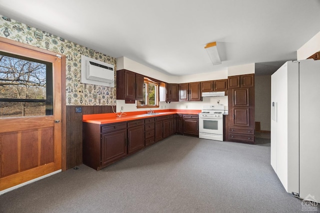 kitchen featuring a wealth of natural light, sink, light colored carpet, and white appliances