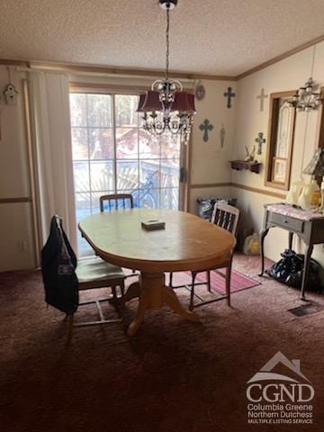 dining area with ornamental molding, carpet floors, a textured ceiling, and a chandelier