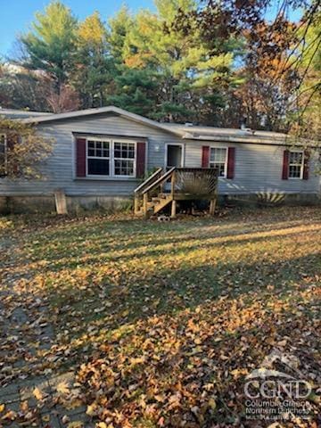 view of front of house with a deck and a front lawn