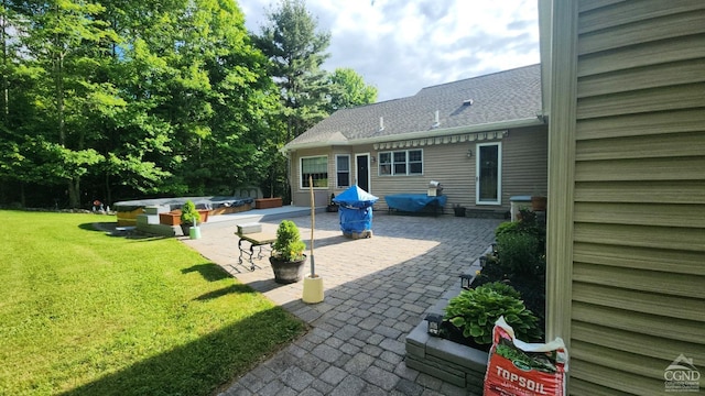 rear view of house featuring a patio area and a lawn