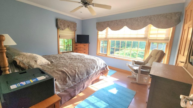 bedroom featuring ceiling fan, crown molding, and multiple windows