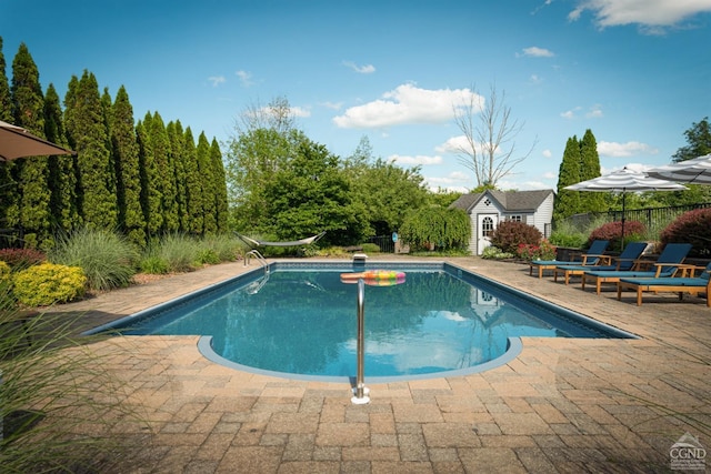 outdoor pool with fence, an outdoor structure, and a patio area