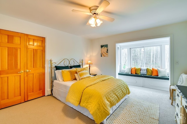 carpeted bedroom featuring ceiling fan and a closet