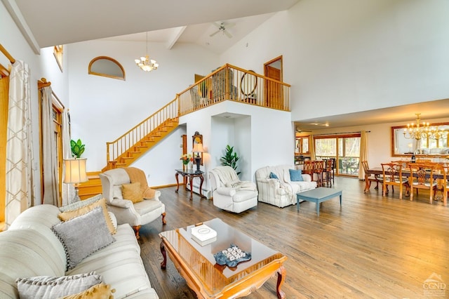 living room featuring hardwood / wood-style flooring, ceiling fan with notable chandelier, beam ceiling, and high vaulted ceiling