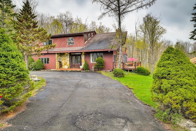 view of front of property featuring a wooden deck and a front lawn