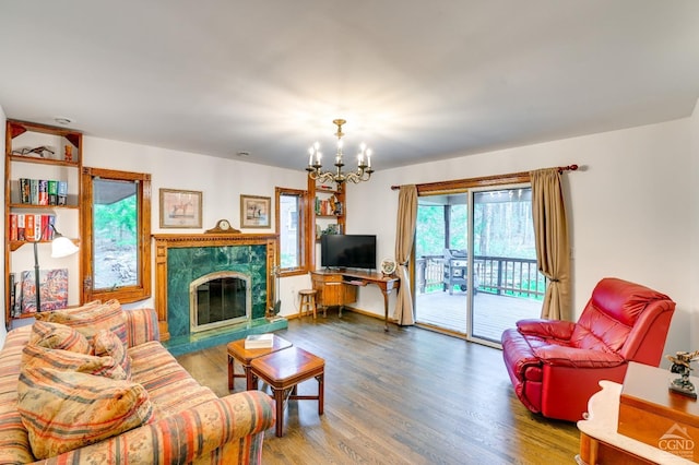 living room featuring wood-type flooring, a high end fireplace, and a chandelier